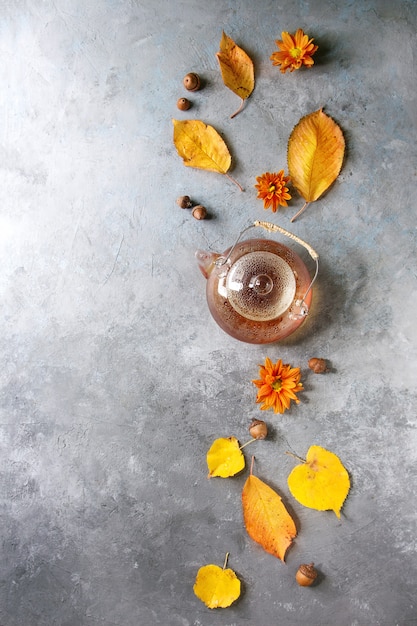 Glass teapot with autumn leaves