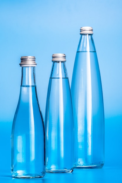 Glass water bottles on a light blue