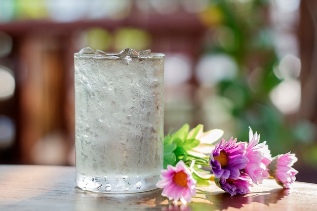 glass of water and fake flower on wood table