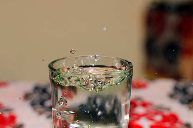 A glass of water macro photoshot with scattering water.