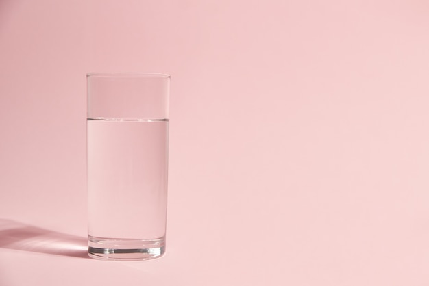 Glass of water on pink