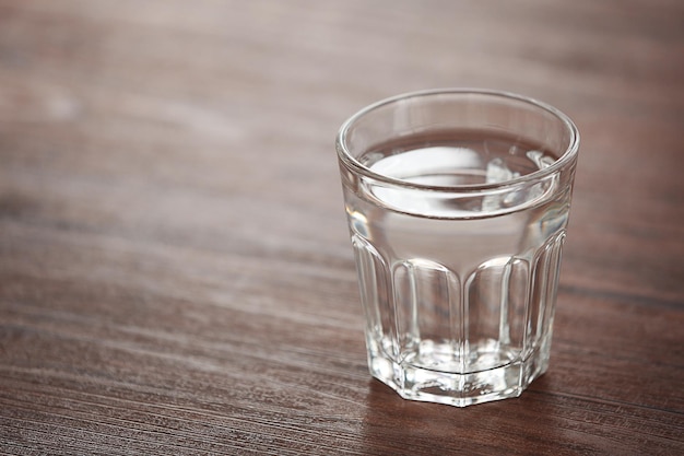 Glass of water on wooden background