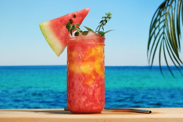 Glass of watermelon drink on tropical beach bar