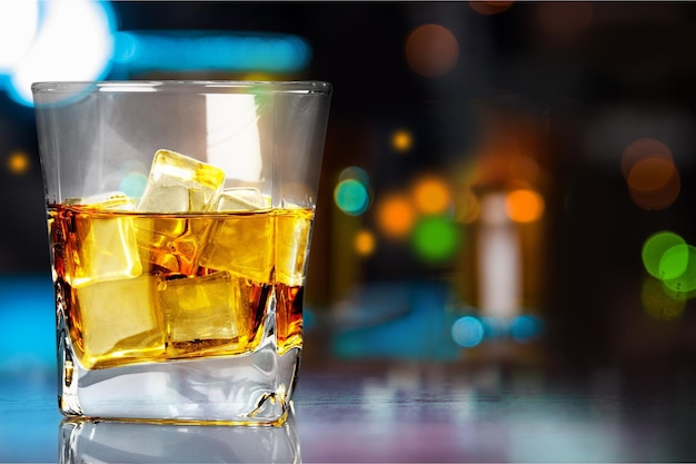 Glass of whiskey and ice isolated on dark background