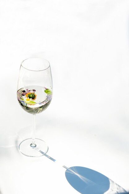 A glass of white wine Minimalism Glass with wine and berries flowers A glass of water