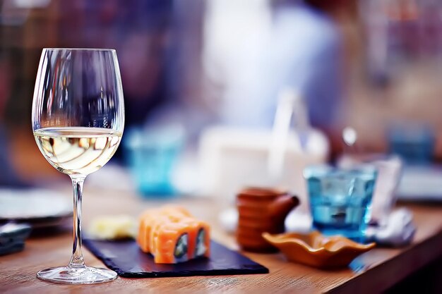 glass of white wine in the restaurant / white wine in the interior of the restaurant a table with glasses of wine, a romantic summer