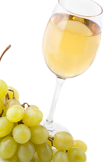 Glass of white wine and white grapes on white background