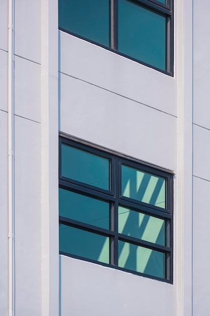 glass windows on modern white building wall with fire escape inside the building