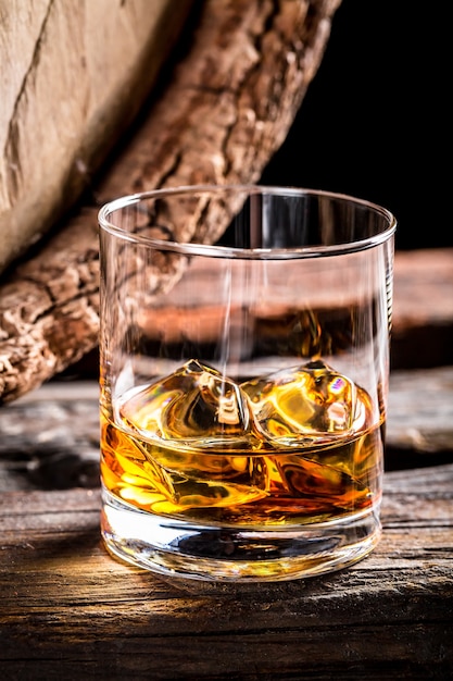 A glass of wine and barrel on wooden table