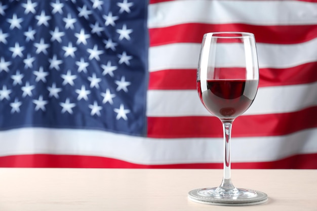 Glass of wine on table against American flag background