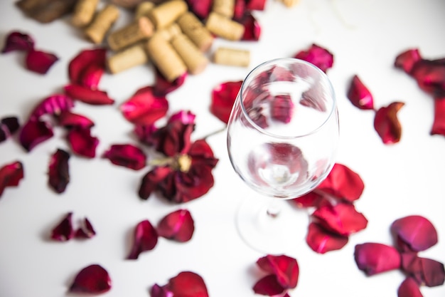 Glass of wine on the table with rose petals