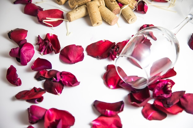 Glass of wine on the table with rose petals