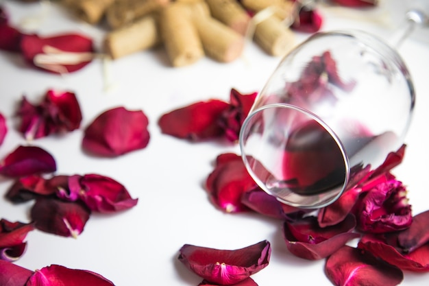 Glass of wine on the table with rose petals