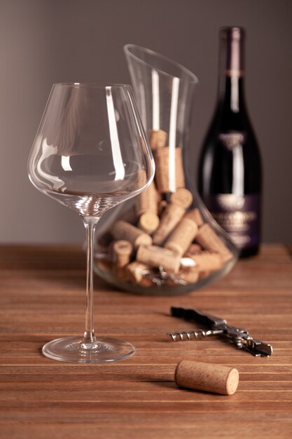 Glass of wine with bottles and corks