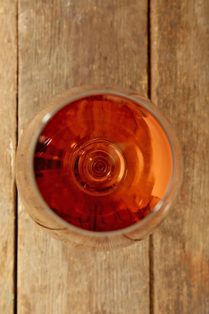 Glass of wine on wooden table Top view