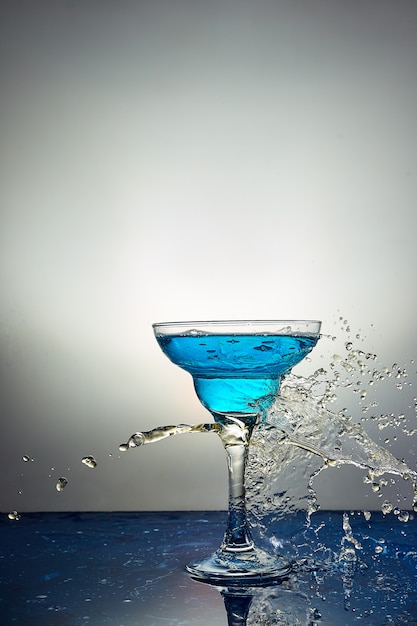 Glass with blue champagne or cocktail. Levitation