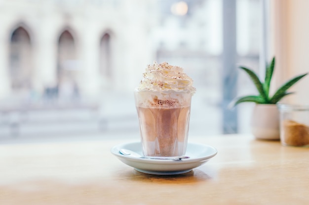 Glass with coffee mocha near the window