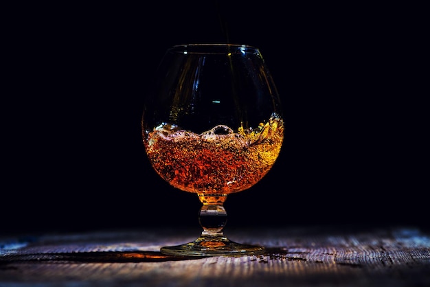 Glass with cognac on a wooden background