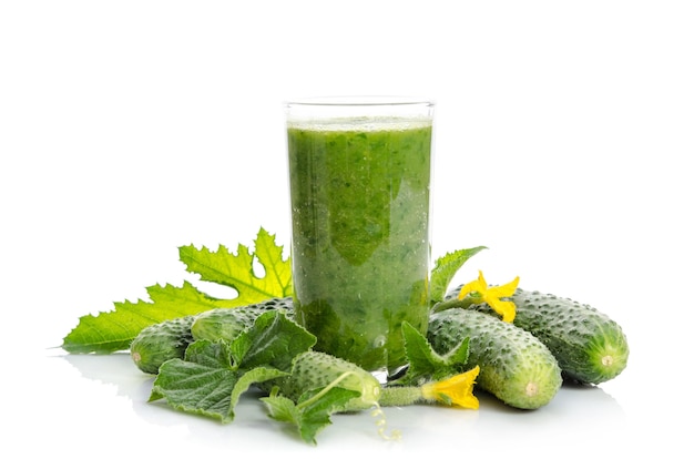 Glass with green smoothie and cucumbers, flowers, leaves isolated