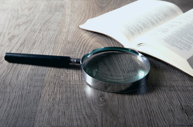 glass with magnifier on a wooden background