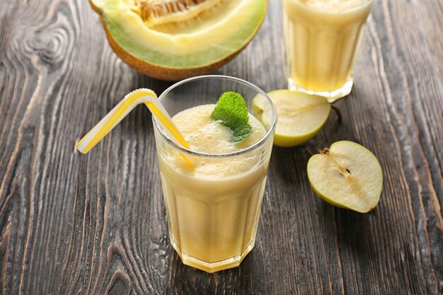 Glass with melon smoothie on table