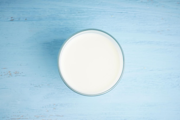 Glass with milk on wooden table Top view