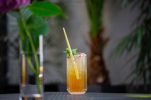 Glass with orange mojito cocktail with lemon and mint, cold refreshing drink or beverage with ice on bright background. Overhead view, copy space. Advertising for cafe menu