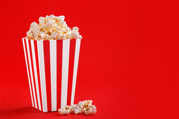 Glass with popcorn on a red background