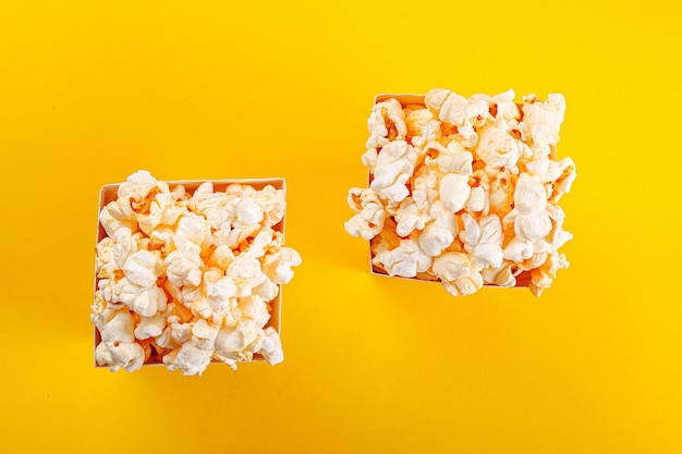 Glass with popcorn on a yellow background