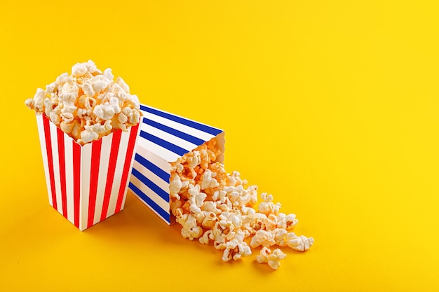 Glass with popcorn on a yellow background