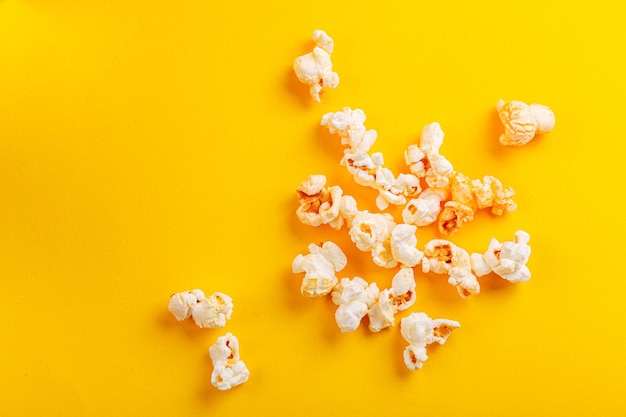 Glass with popcorn on a yellow background