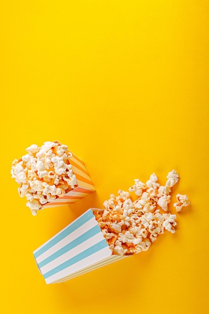 Glass with popcorn on a yellow background