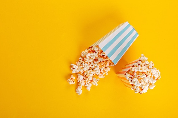 Glass with popcorn on a yellow background