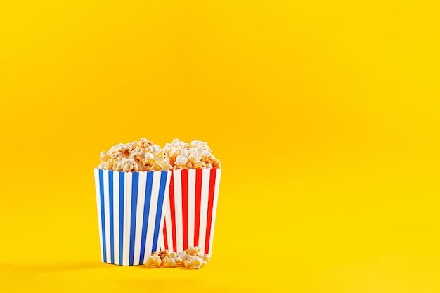 Glass with popcorn on a yellow background