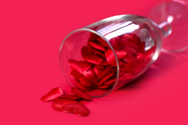 Glass with small red hearts on a pink background