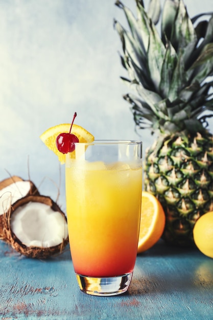 Glass with tasty exotic cocktail on table