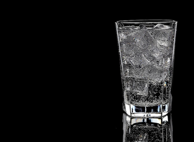 Glass with water and ice on the black background copy space