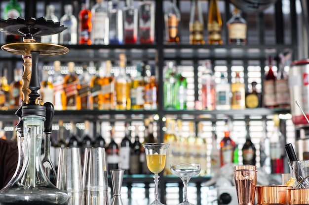 Glass with yellow lemon cocktail on the bar on a blurred bar background the drinks is decorated