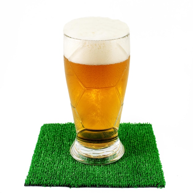 Glasses of beer on green grass at table