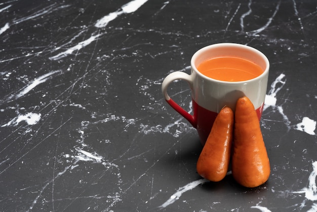 Glasses of carrot juice with vegetables on table close up