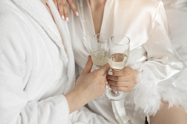 glasses of champagne in the hands of lovers in bathrobes