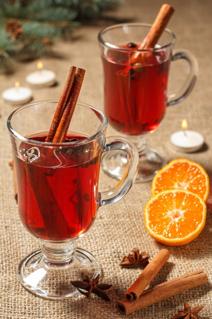 Glasses of Christmas mulled wine with spices and orange on sackcloth