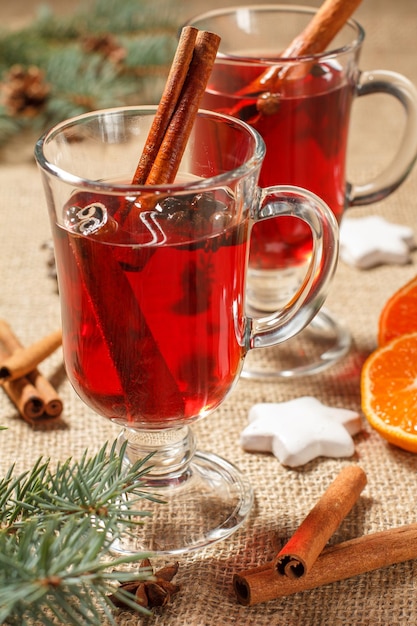 Glasses of Christmas mulled wine with spices and orange on sackcloth