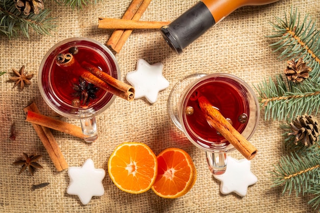 Glasses of Christmas mulled wine with spices and orange on sackcloth