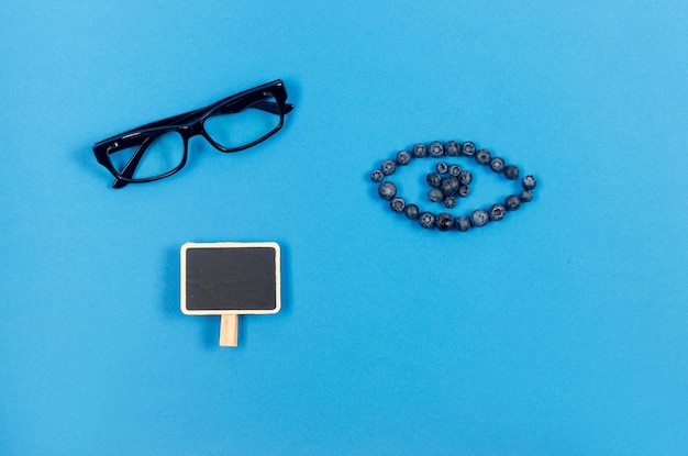 Glasses and fresh blueberries on blue background