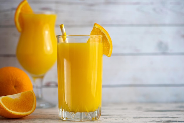 Glasses of Fresh Orange Juice on light wooden background Side view With copy space