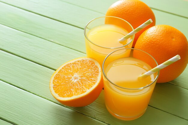 Glasses of fresh orange juice on wooden table