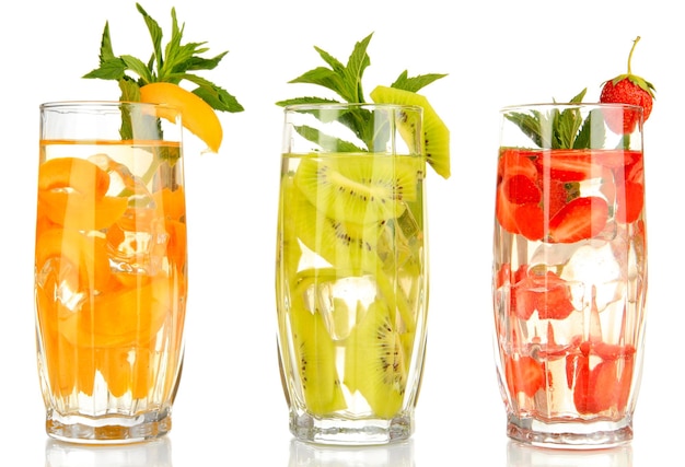 Glasses of fruit drinks with ice cubes isolated on white