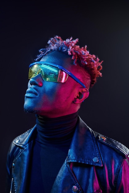 In glasses Futuristic neon lighting Young african american man in the studio