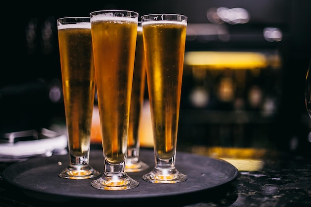 glasses of light beer stand on a tray in a bar, close-up